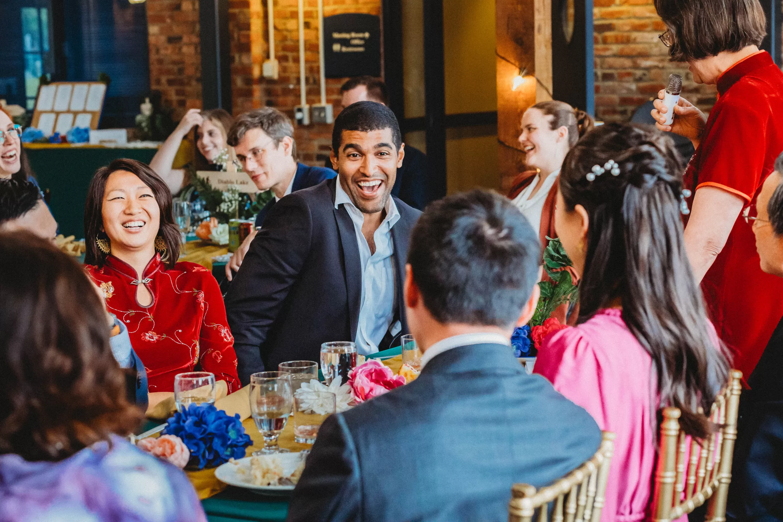 Candid wedding reception photo of family laughing at Golden Gardens Bathhouse in Seattle, WA