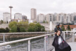 Groom getting ready with a luxury barber service at the Point at Pier 70 in Seattle on the balcony with the Space Needle in the distance