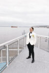 Groom posing for portrait on the balcony at The Point at Pier 70 wedding in Seattle with Puget Sound in the background
