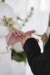 Groom placing ring on his partner's hand during their wedding ceremony at The Point at Pier 70