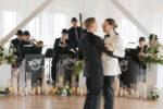 Grooms share first dance in front of 7-piece jazz band at The Point at Pier 70 wedding celebration