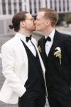 Grooms sharing a celebratory kiss at their luxury Seattle editorial wedding at the Point at Pier 70