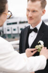 Groom's attaching each other's boutonniere's and sharing a meaningful look prior to their luxury Seattle Wedding at the Point at Pier 70