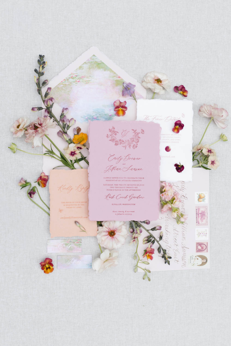 Pastel pink, orange, white, and blue wedding stationery with floral details