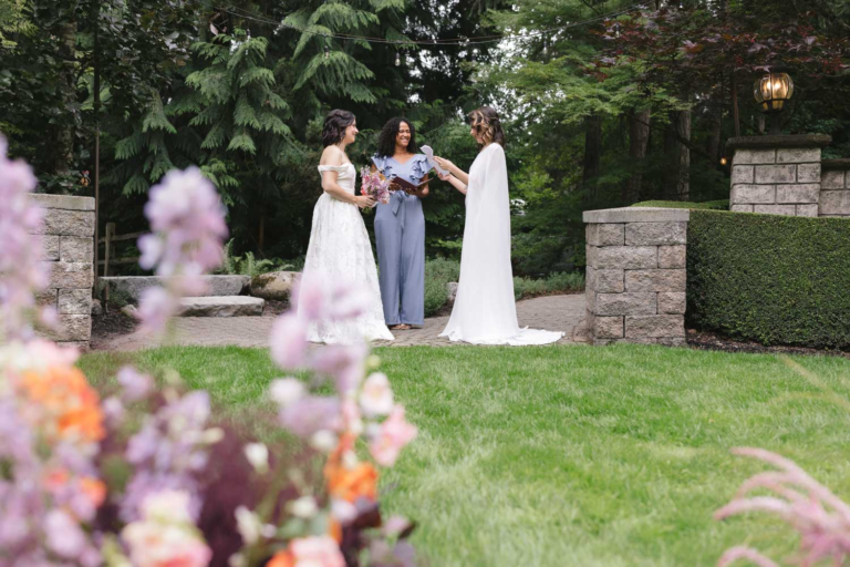 Two brides exchange vows on the lawns of Rock Creek Gardens for their wedding ceremony