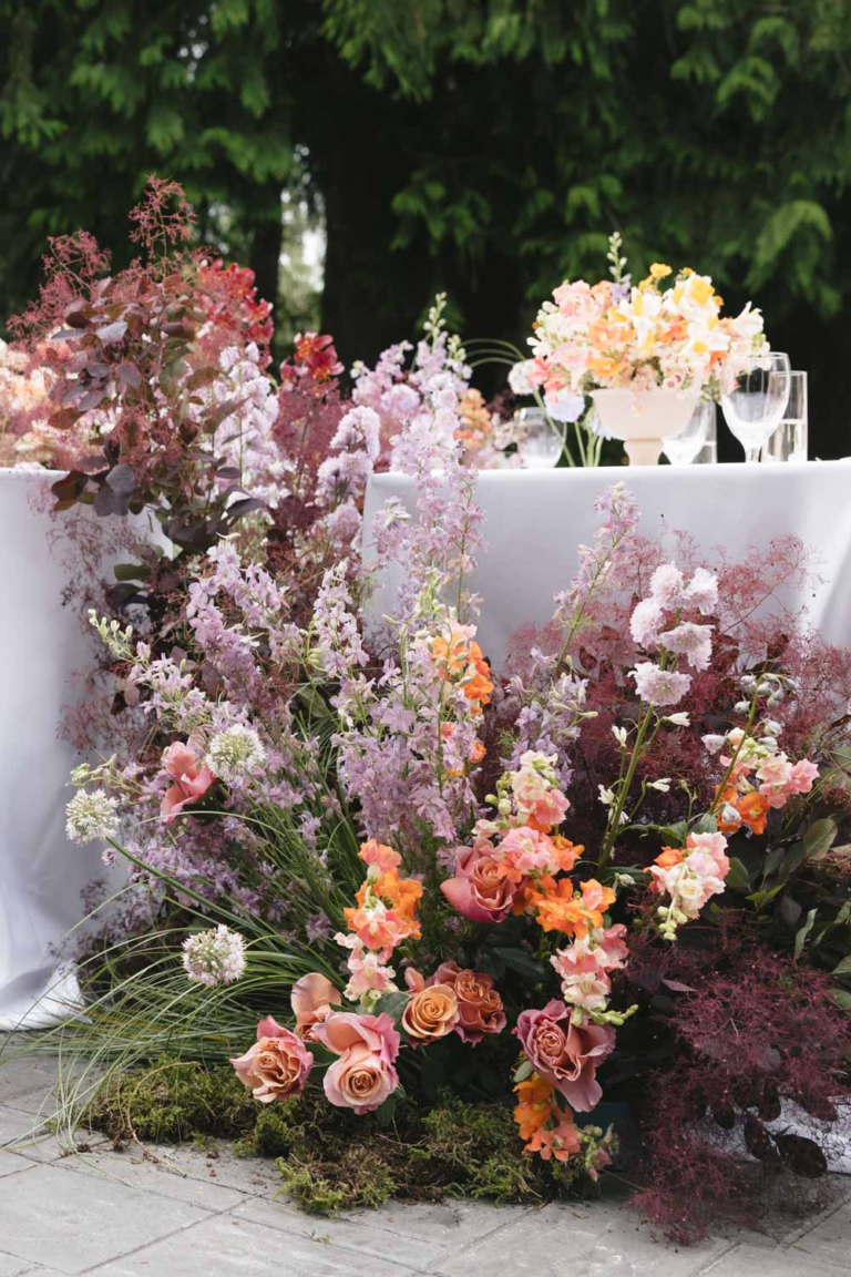 Whimsical, sculptural and colorful florals at the end of a reception table