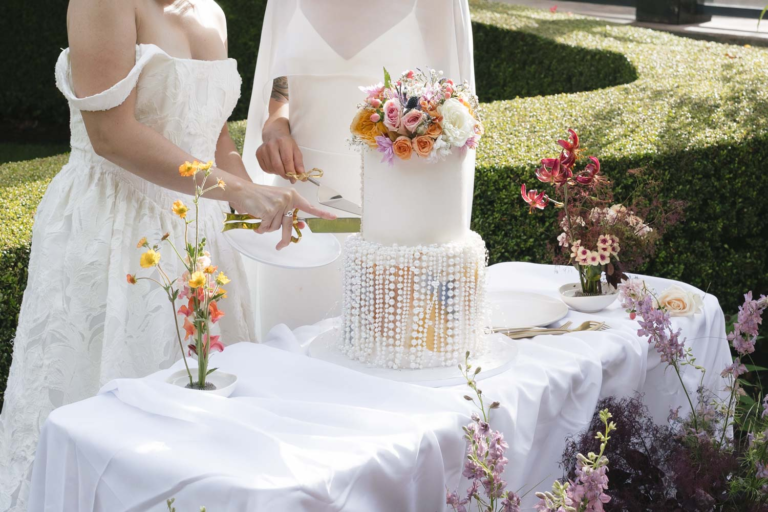 Close-up of brides cutting their wedding cake at Rock Creek Gardens in Puyallup, WA