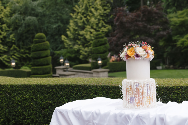 Two-tier wedding cake displayed on a white tablecloth at Rock Creek Gardens
