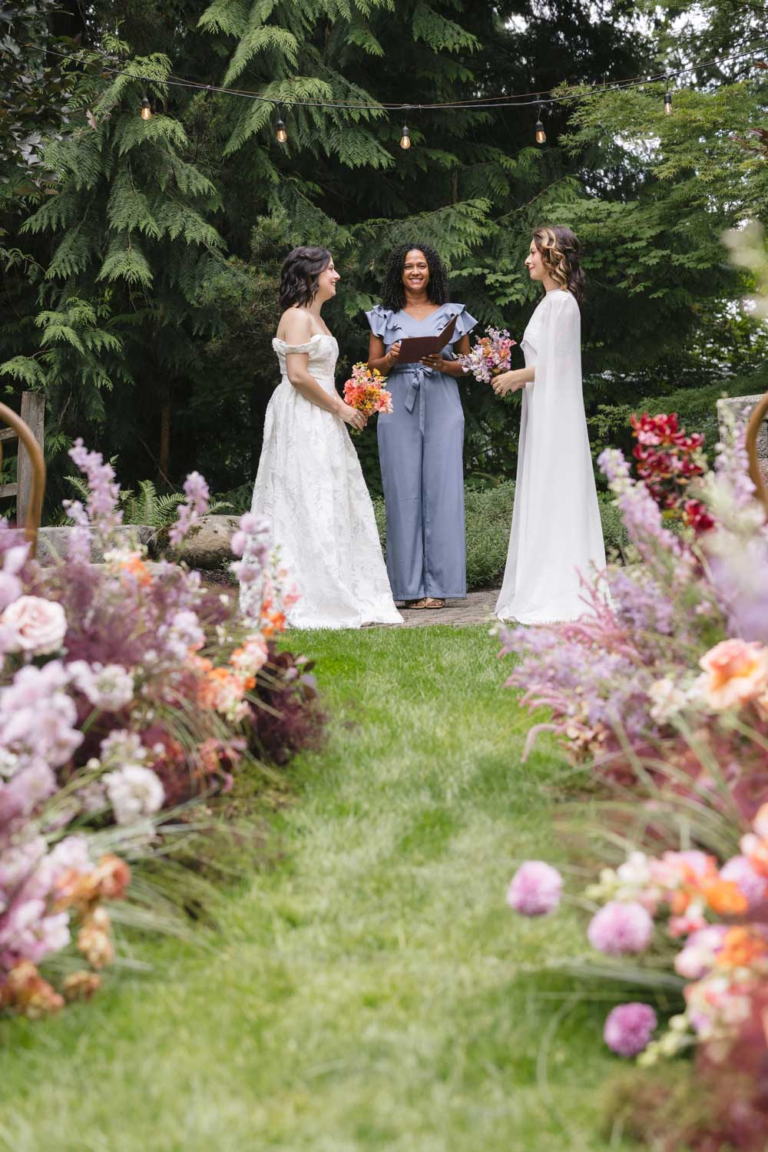 Two brides exchange vows on the lawns of Rock Creek Gardens for their wedding ceremony