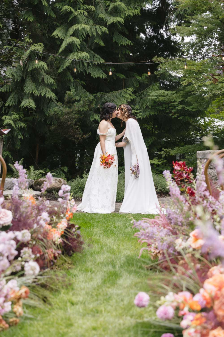 Two brides share their first kiss as wives following their wedding ceremony at Rock Creek Gardens
