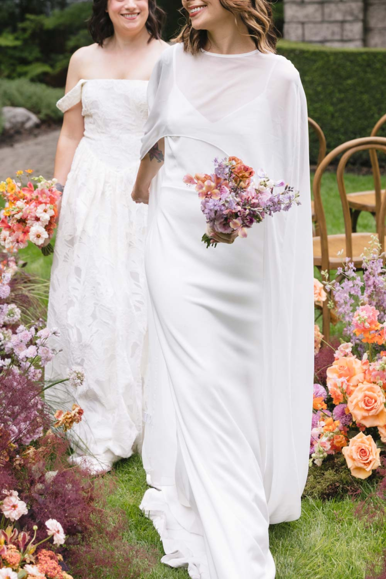 Two brides walking back up the aisle holding their wedding bouquets