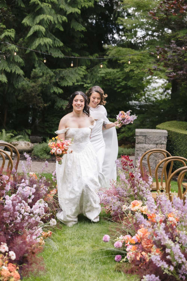 Two brides run back up the aisle at Rock Creek Gardens after their wedding ceremony