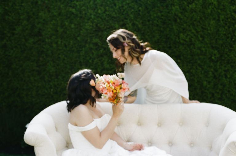 A lesbian couple lean in for a kiss at Rock Creek Gardens.