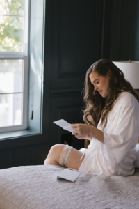 Bride in her silk robe reading a letter on her wedding day written to her by the groom at Hotel Scandi in Poulsbo, WA