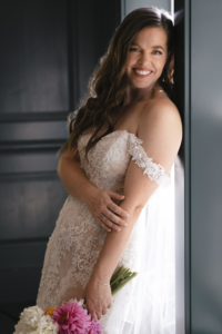 Bride leans against window frame at Hotel Scandi in Poulsbo, WA